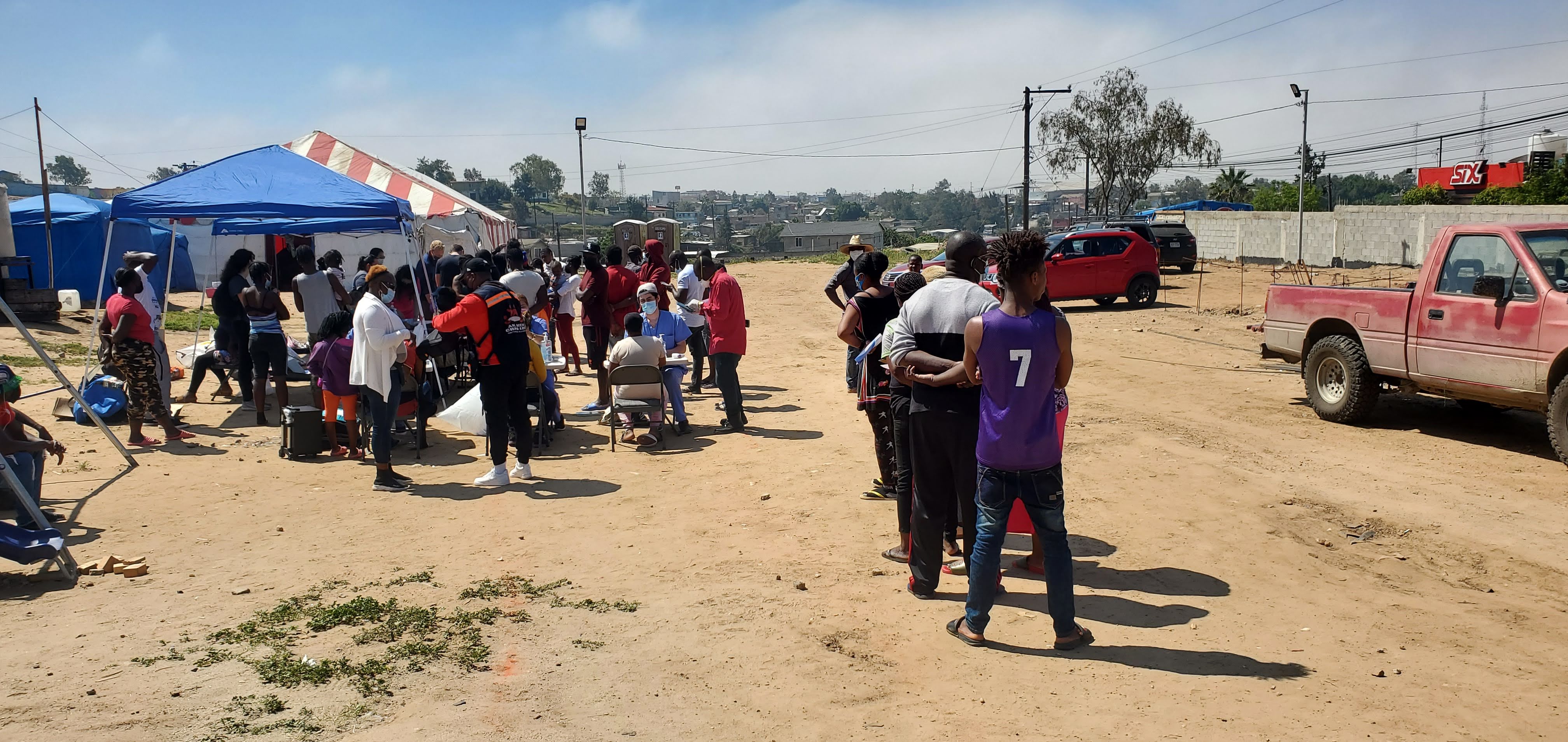 Migrants gathered at a humanitarian aid station, representing field research on the health impacts of detention and deportation